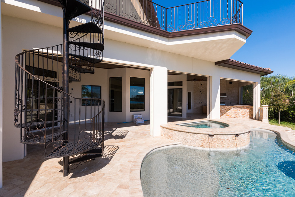 Esempio di una grande piscina a sfioro infinito mediterranea personalizzata dietro casa con pavimentazioni in cemento