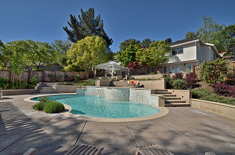 Large elegant backyard stamped concrete and custom-shaped natural pool fountain photo in San Francisco