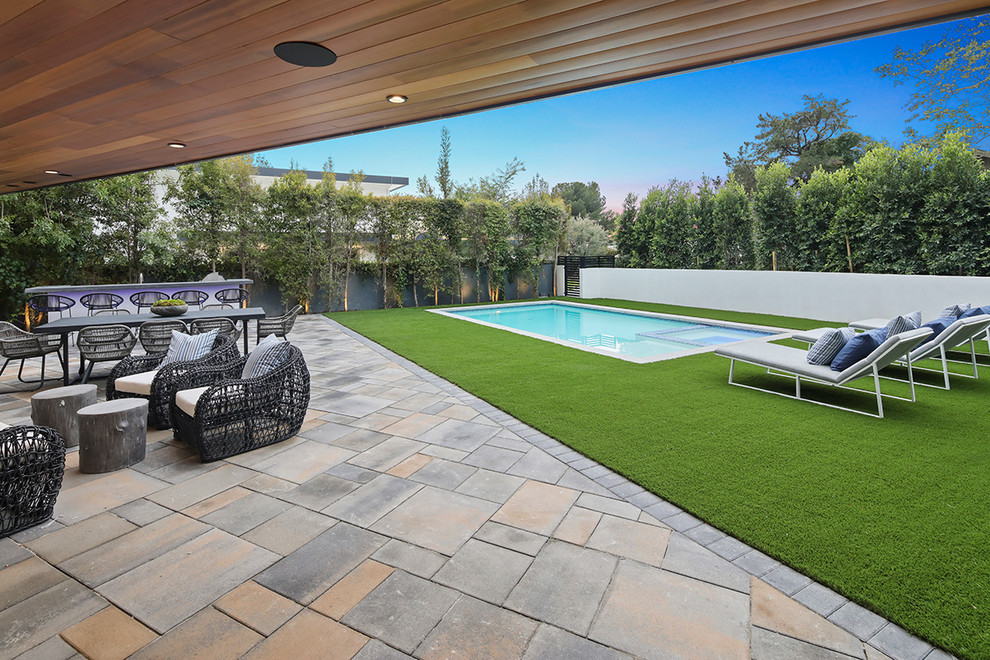 Großes Modernes Sportbecken hinter dem Haus in rechteckiger Form mit Grillplatz, Pool-Gartenbau und Natursteinplatten in Los Angeles