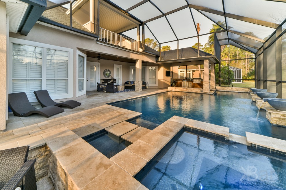 Diseño de piscina actual rectangular en patio trasero con adoquines de piedra natural