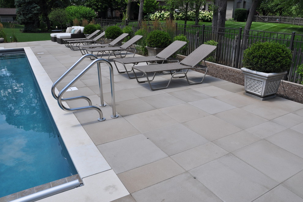 Imagen de piscina natural clásica renovada extra grande a medida en patio trasero con adoquines de hormigón