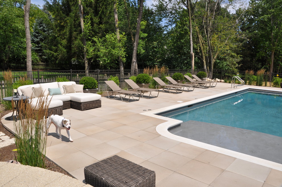 Foto de piscina natural clásica renovada extra grande a medida en patio trasero con adoquines de hormigón