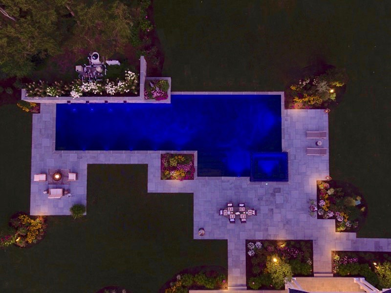 Ispirazione per un'ampia piscina monocorsia contemporanea rettangolare dietro casa con una vasca idromassaggio e pavimentazioni in pietra naturale