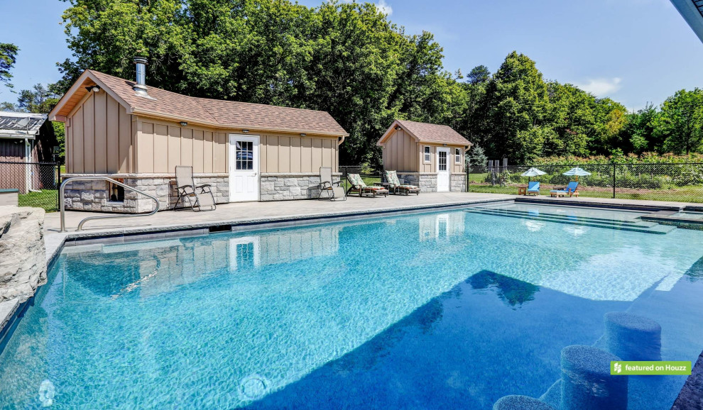 Photo of a large traditional back rectangular swimming pool in Toronto with a pool house and stamped concrete.