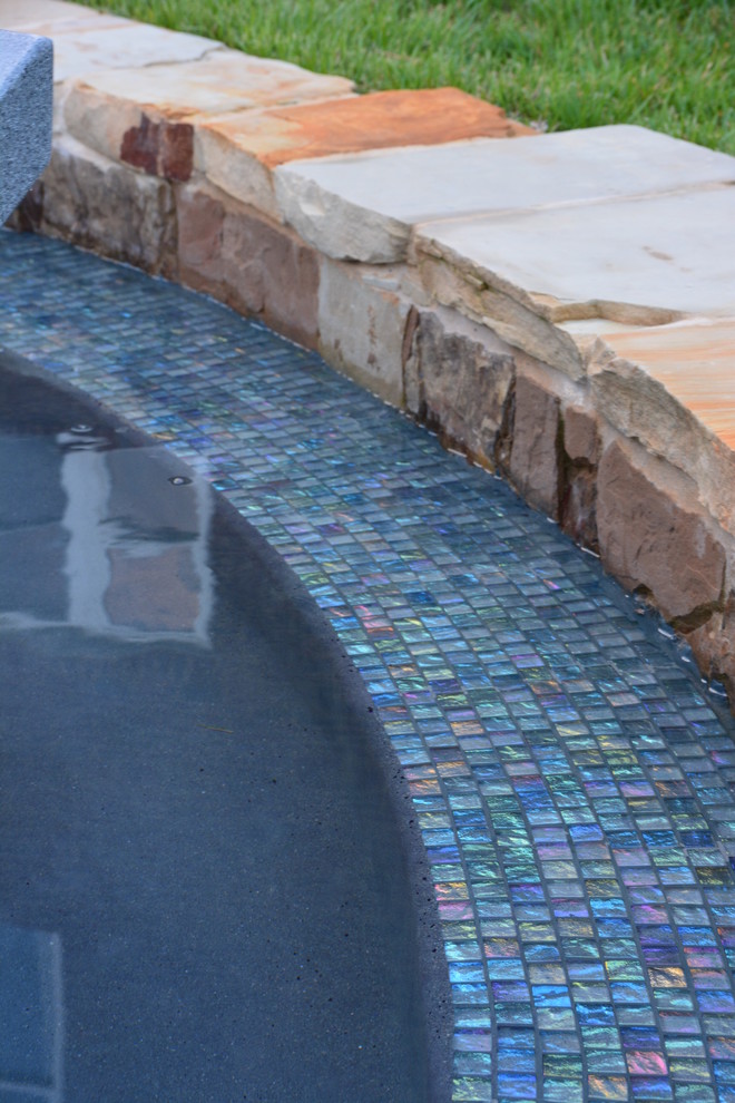 Esempio di una piscina a sfioro infinito american style personalizzata di medie dimensioni e dietro casa con fontane e piastrelle