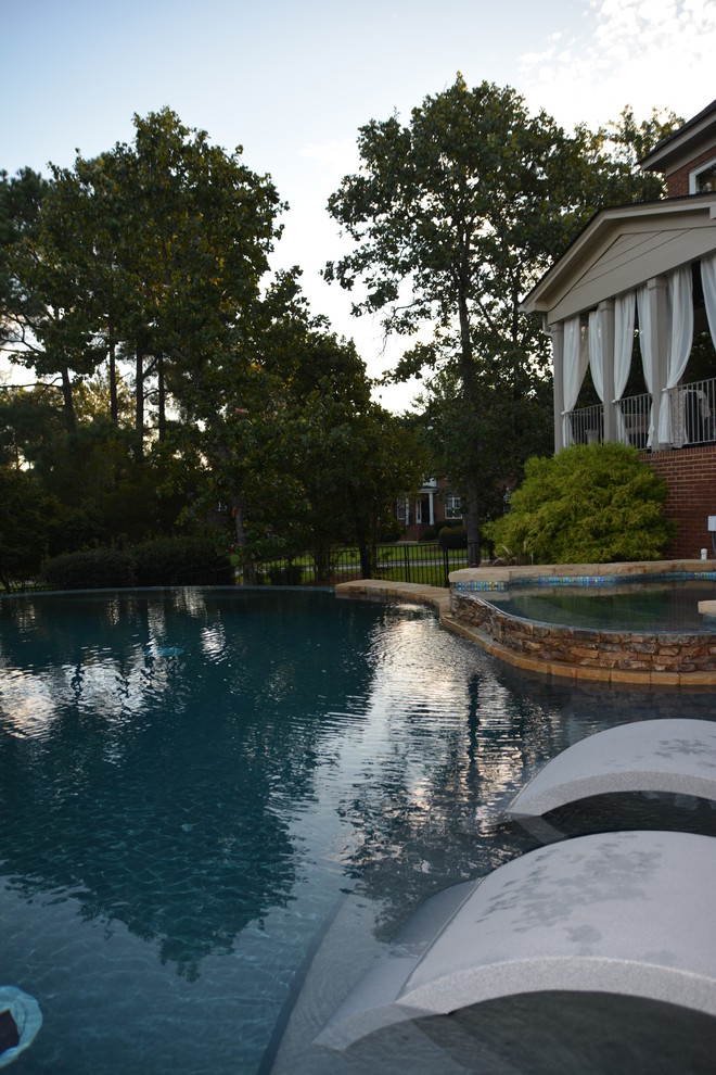 Diseño de piscina con fuente infinita de estilo americano de tamaño medio a medida en patio trasero con suelo de baldosas