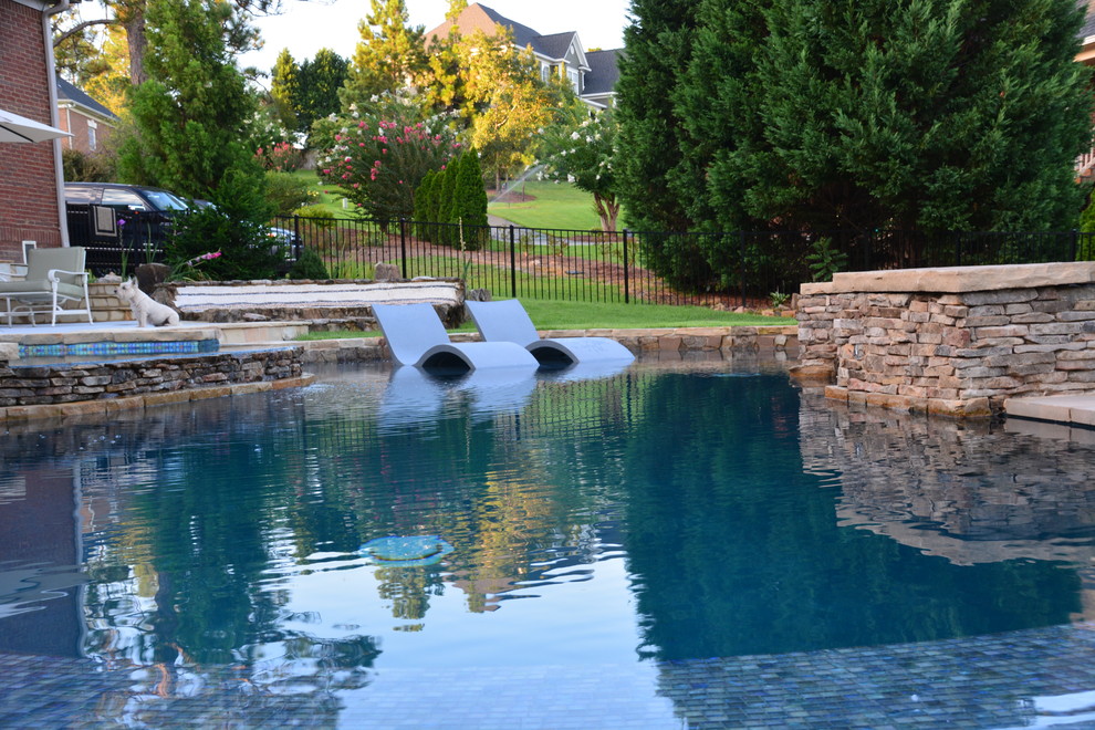 Cette photo montre une piscine à débordement et arrière tendance de taille moyenne et sur mesure avec un point d'eau et du carrelage.