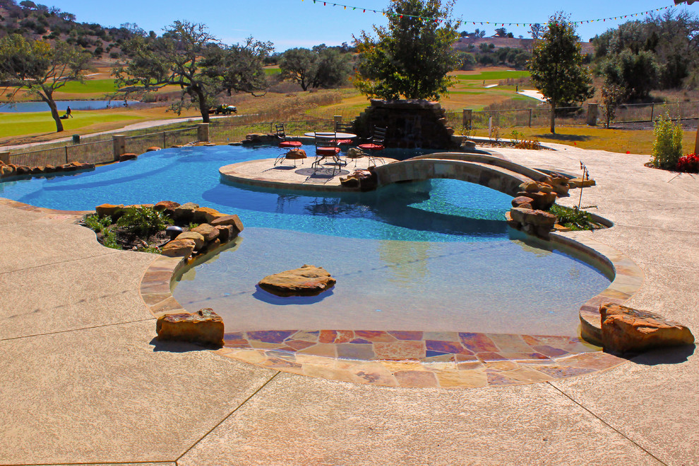 Imagen de piscina con fuente infinita contemporánea extra grande a medida en patio trasero con losas de hormigón