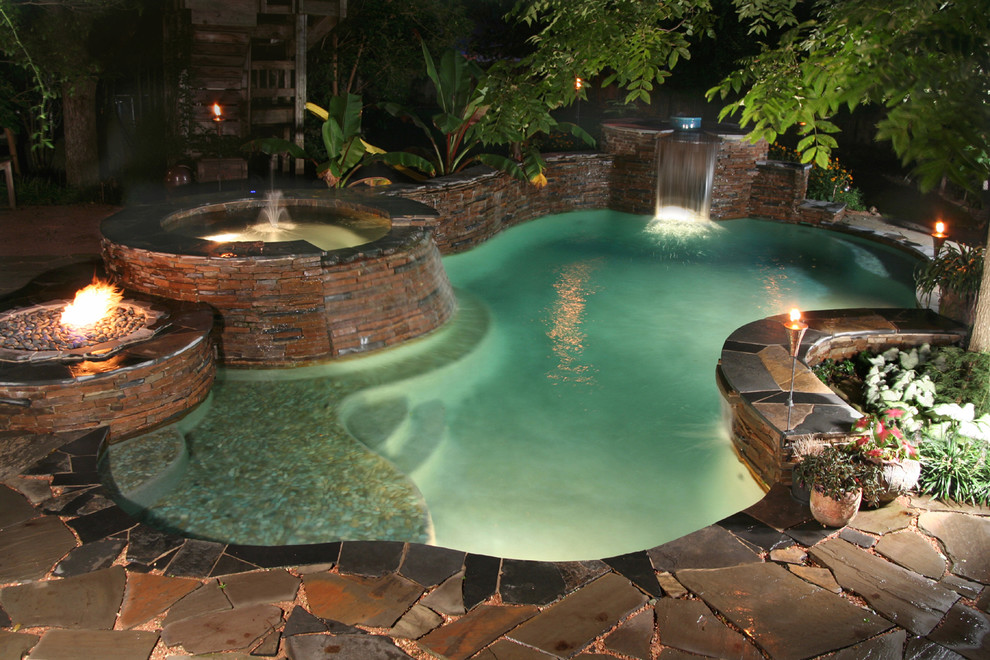 Ejemplo de piscinas y jacuzzis tradicionales de tamaño medio a medida en patio trasero con adoquines de piedra natural