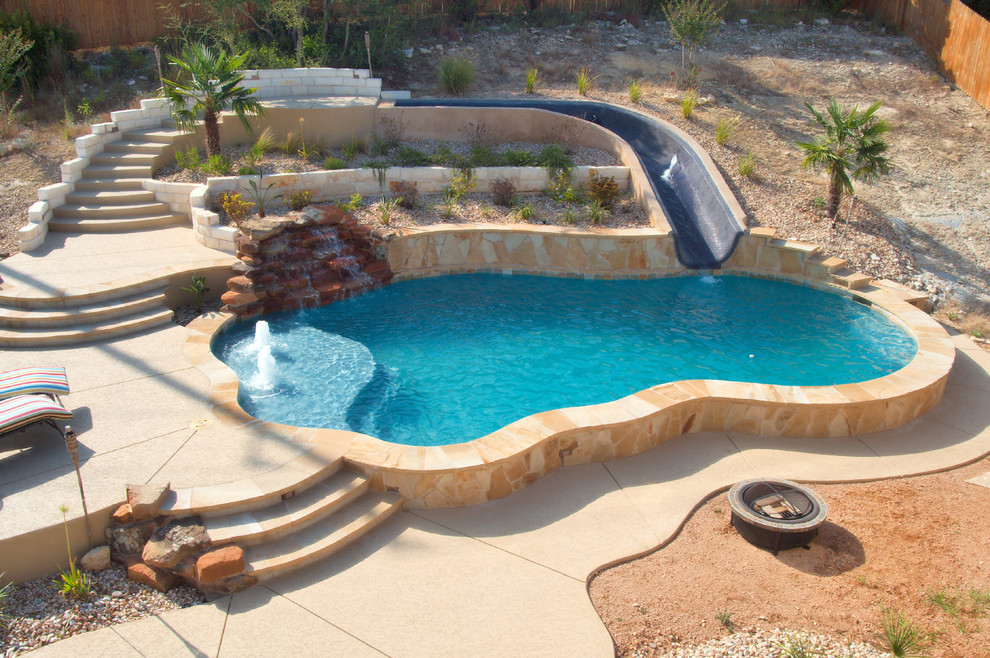 Foto de piscina con tobogán tradicional grande a medida en patio trasero con losas de hormigón