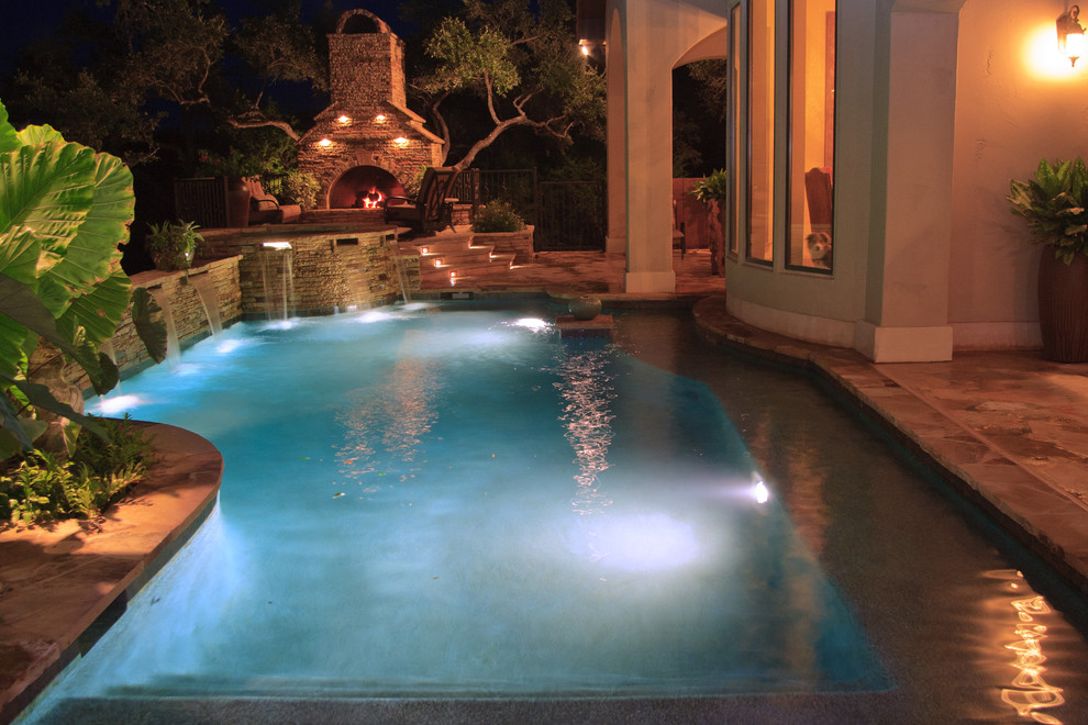 Inspiration for a mid-sized timeless backyard stone and custom-shaped hot tub remodel in Austin