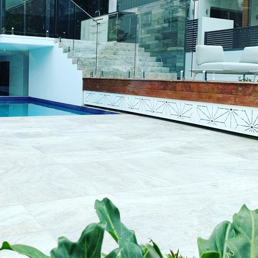 Großer Asiatischer Pool hinter dem Haus in L-Form mit Natursteinplatten in Brisbane