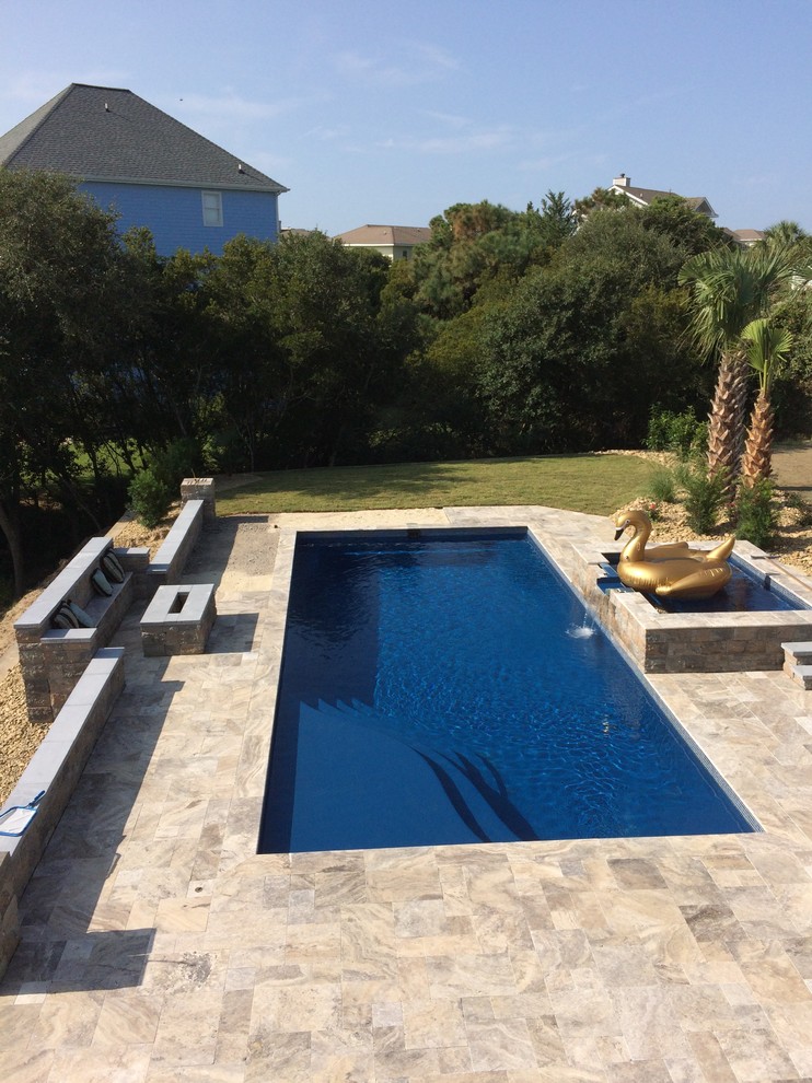 Ispirazione per una grande piscina contemporanea rettangolare dietro casa con fontane e pavimentazioni in pietra naturale