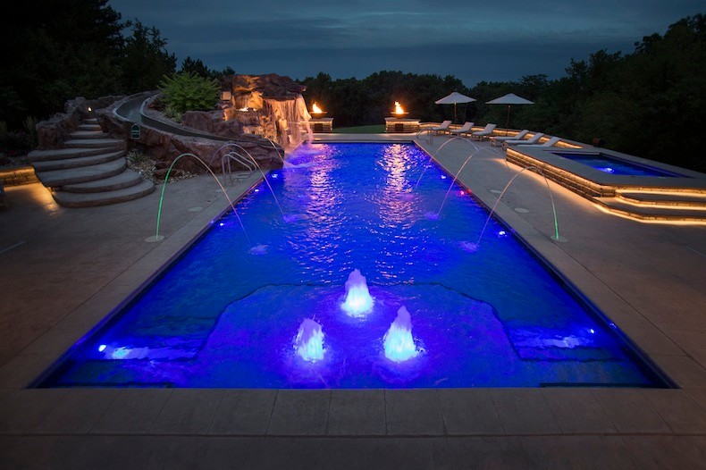 Idee per una grande piscina monocorsia tradizionale rettangolare dietro casa con un acquascivolo e pavimentazioni in cemento
