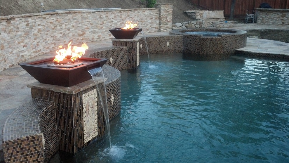 Diseño de piscina con fuente natural moderna a medida en patio trasero con suelo de hormigón estampado