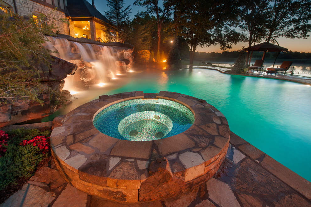 Photo of a large classic custom shaped natural hot tub in Oklahoma City with natural stone paving.