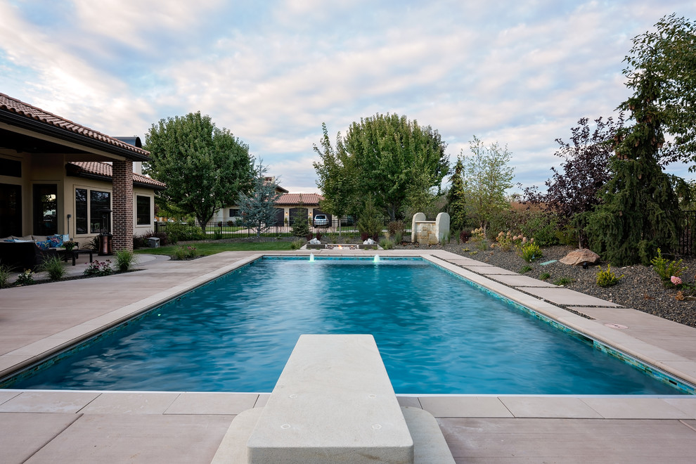 Exemple d'une grande piscine arrière moderne rectangle avec des pavés en béton.