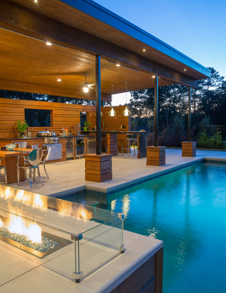 Источник вдохновения для домашнего уюта: большой прямоугольный бассейн на заднем дворе в стиле модернизм с домиком у бассейна и покрытием из декоративного бетона