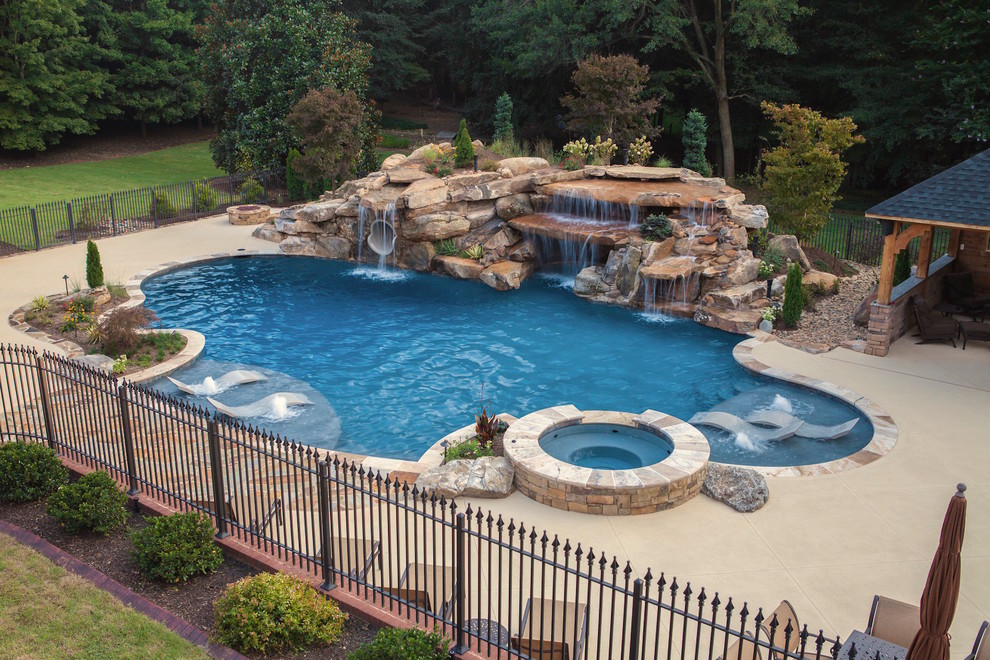 Immagine di una piscina monocorsia country personalizzata di medie dimensioni e dietro casa con fontane e pavimentazioni in pietra naturale