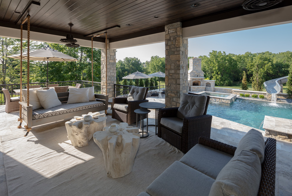 Imagen de piscina con tobogán clásica renovada extra grande a medida en patio trasero con adoquines de piedra natural