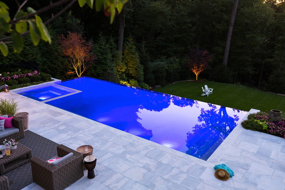 Идея дизайна: огромный спортивный, прямоугольный бассейн на заднем дворе в современном стиле с джакузи и покрытием из каменной брусчатки