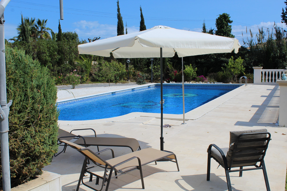 Immagine di una piscina monocorsia mediterranea rettangolare di medie dimensioni e dietro casa con pavimentazioni in cemento