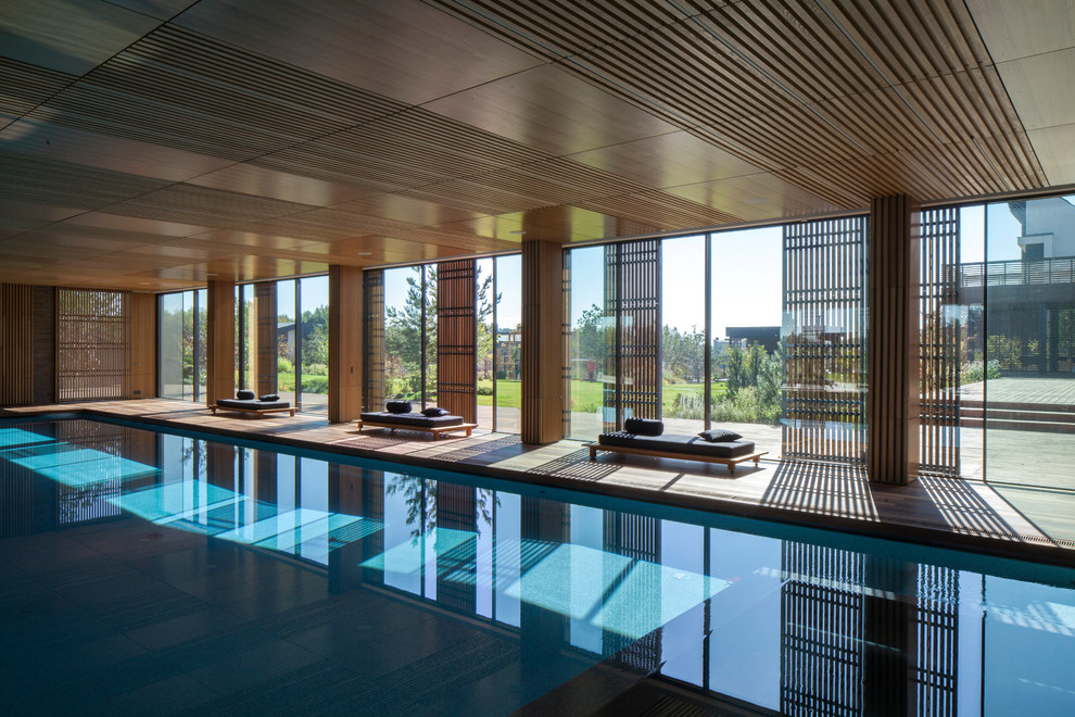 Ejemplo de piscina alargada minimalista grande interior y rectangular con entablado