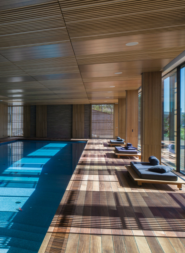 Diseño de piscina alargada moderna grande interior y rectangular con entablado