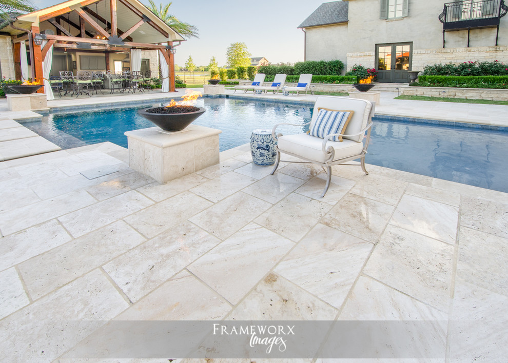 Photo of a mediterranean back swimming pool in New Orleans with a pool house and natural stone paving.