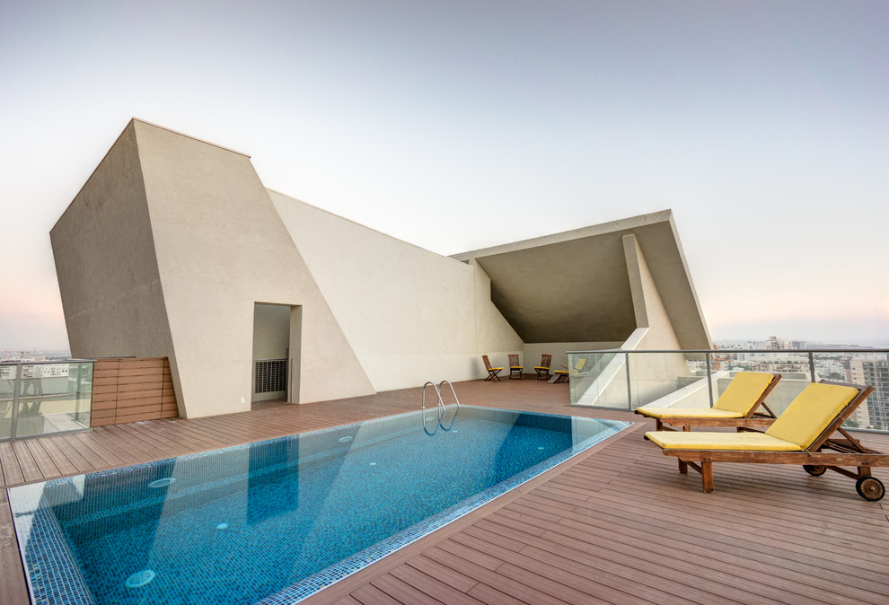 Exemple d'une grande piscine sur toit tendance rectangle avec une terrasse en bois.