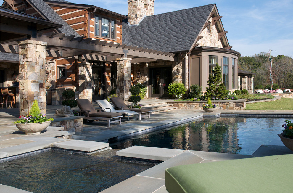 Cette image montre une piscine arrière chalet de taille moyenne et rectangle avec des pavés en pierre naturelle et un bain bouillonnant.