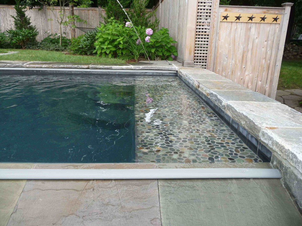 Ispirazione per una piscina a sfioro infinito stile marinaro rettangolare dietro casa con fontane e pavimentazioni in pietra naturale