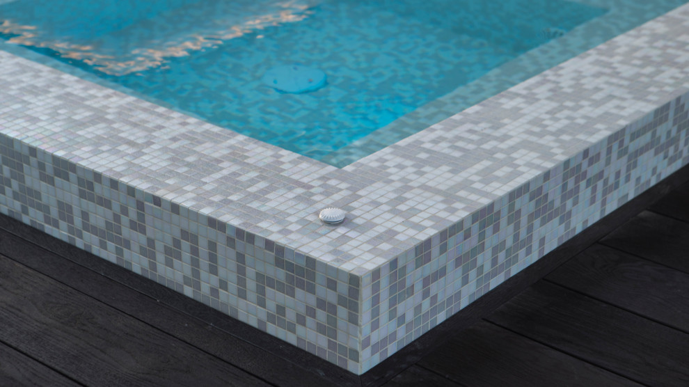 Imagen de piscina infinita tropical de tamaño medio tipo riñón en patio lateral con suelo de baldosas