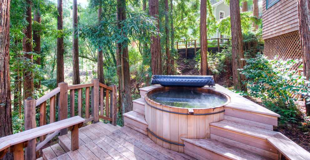 Inspiration pour une piscine arrière chalet de taille moyenne et ronde avec un bain bouillonnant et une terrasse en bois.