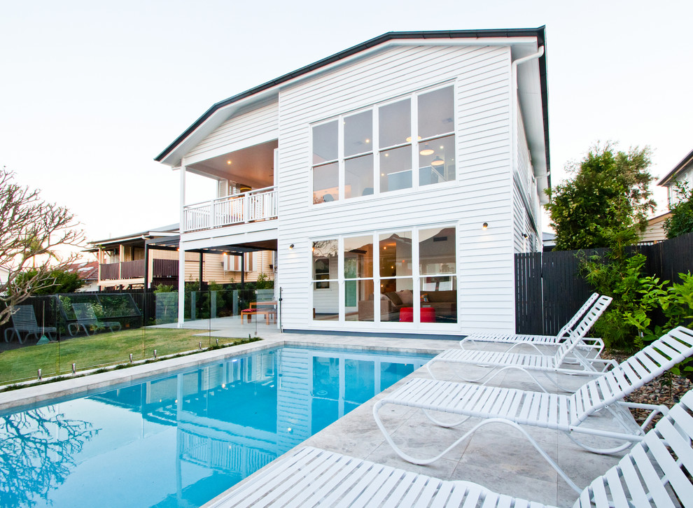 Immagine di una piscina monocorsia tradizionale rettangolare dietro casa con pavimentazioni in cemento