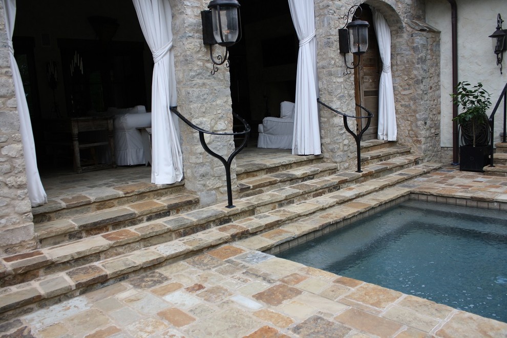 Aménagement d'une piscine méditerranéenne de taille moyenne et rectangle avec une cour et des pavés en pierre naturelle.