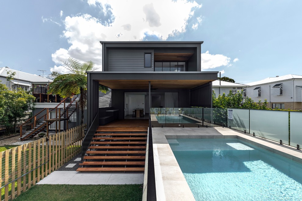 Cette photo montre une piscine hors-sol et arrière tendance rectangle avec une terrasse en bois.