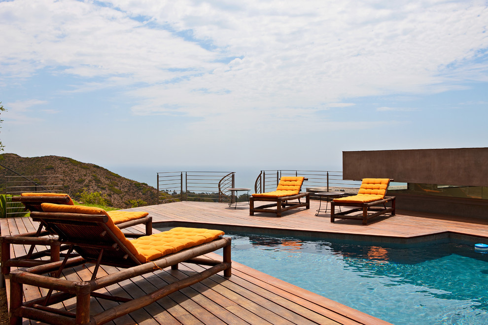 Exemple d'une piscine bord de mer sur mesure avec une terrasse en bois.