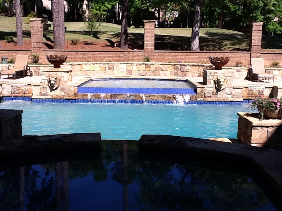 Idee per una grande piscina minimalista rettangolare dietro casa con una vasca idromassaggio e cemento stampato