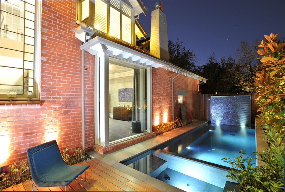 Contemporary side rectangular hot tub in Melbourne with natural stone paving.
