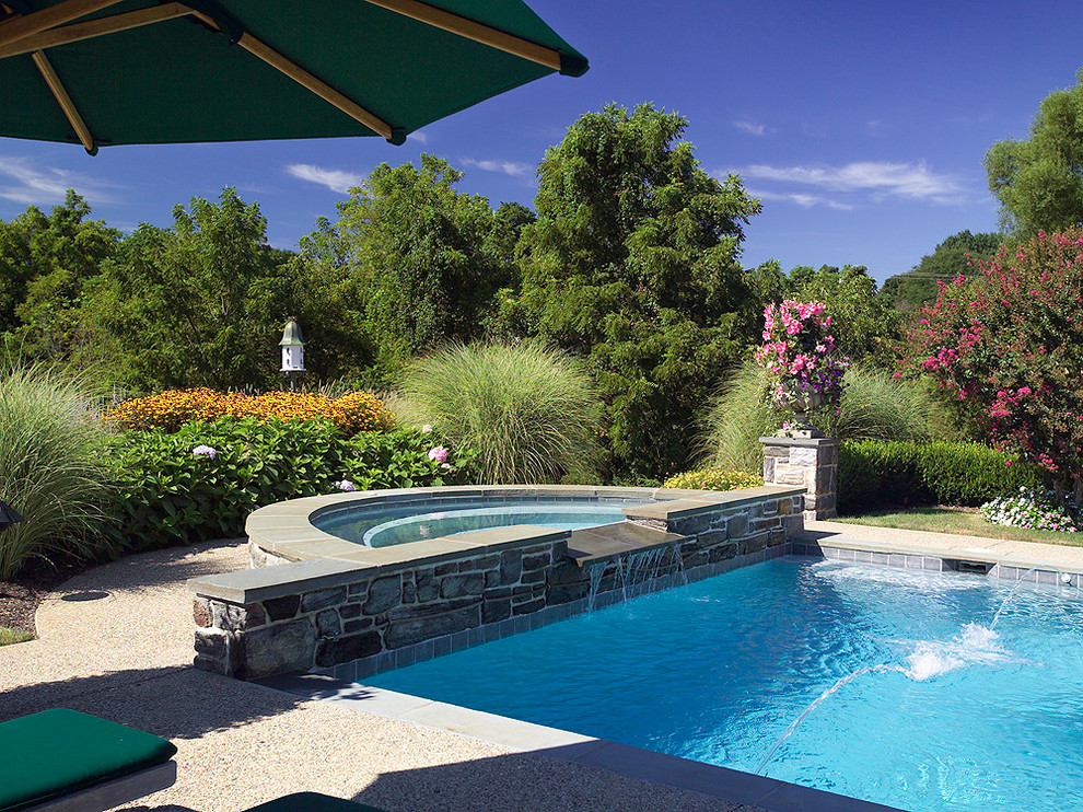 На фото: бассейн среднего размера, произвольной формы на заднем дворе в викторианском стиле с фонтаном и покрытием из гравия с