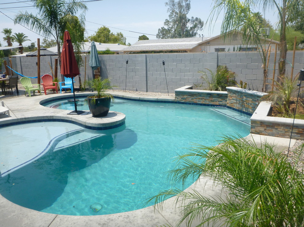 Idee per una grande piscina tradizionale personalizzata dietro casa con pavimentazioni in cemento