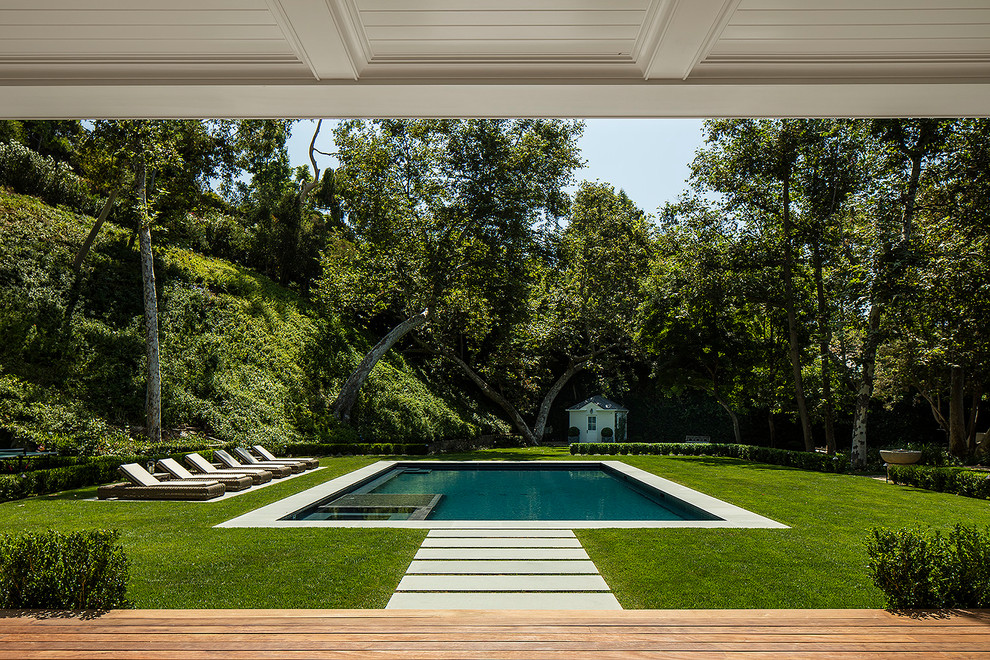 Classic back rectangular swimming pool in Los Angeles with a pool house.
