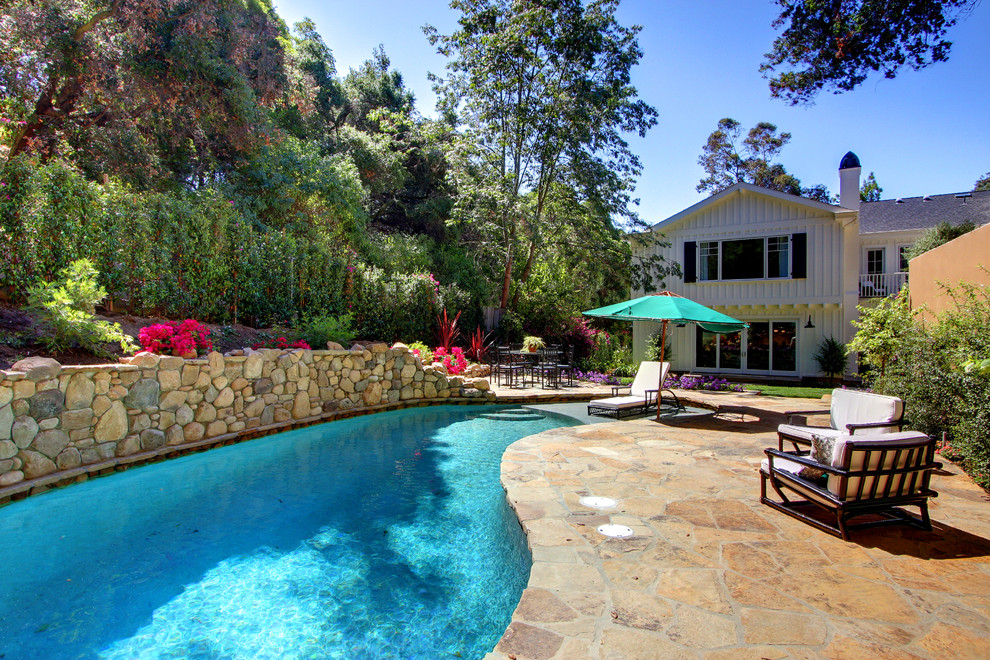 Diseño de piscina tradicional a medida en patio trasero con adoquines de piedra natural