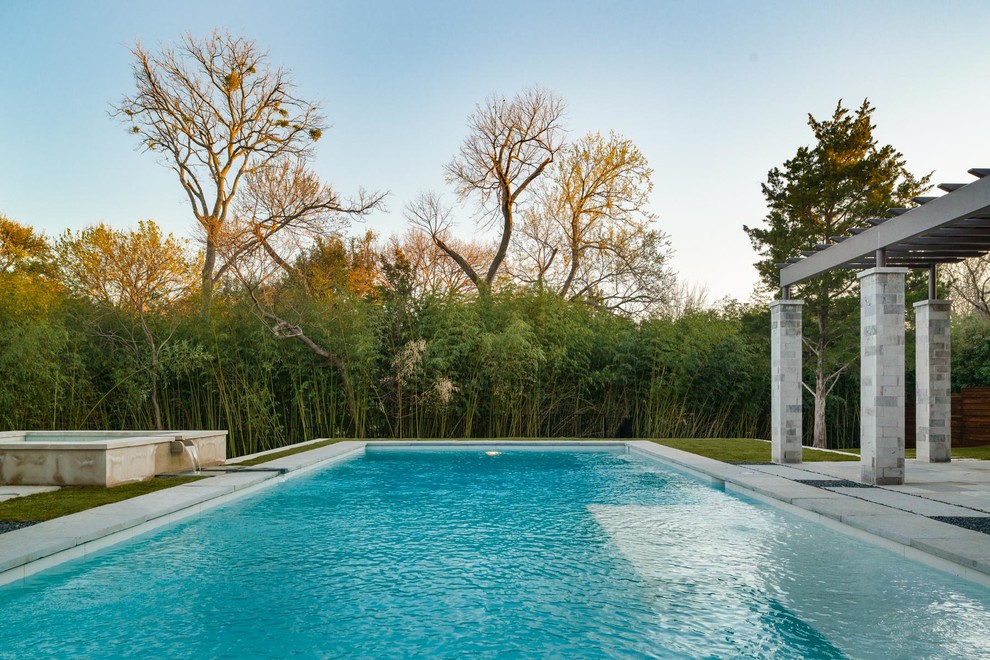 Ejemplo de piscina con fuente clásica renovada grande rectangular en patio trasero con granito descompuesto