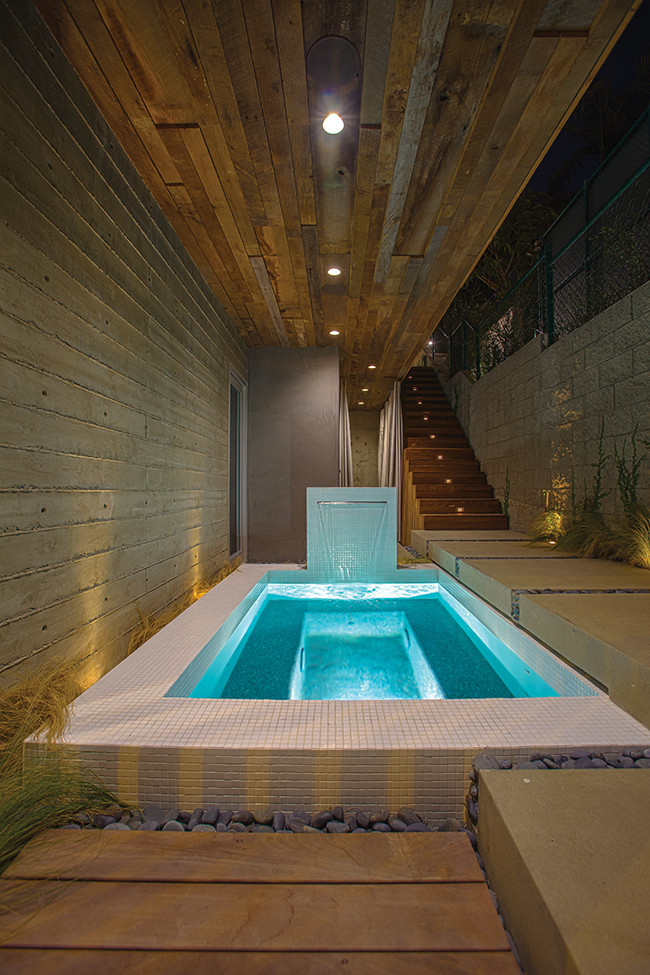 Foto de piscina con fuente natural moderna pequeña rectangular en patio lateral con suelo de baldosas