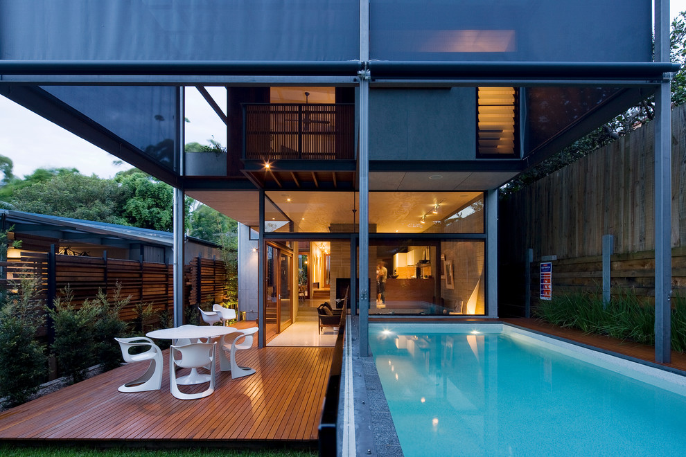 Idée de décoration pour une piscine arrière design rectangle avec une terrasse en bois.