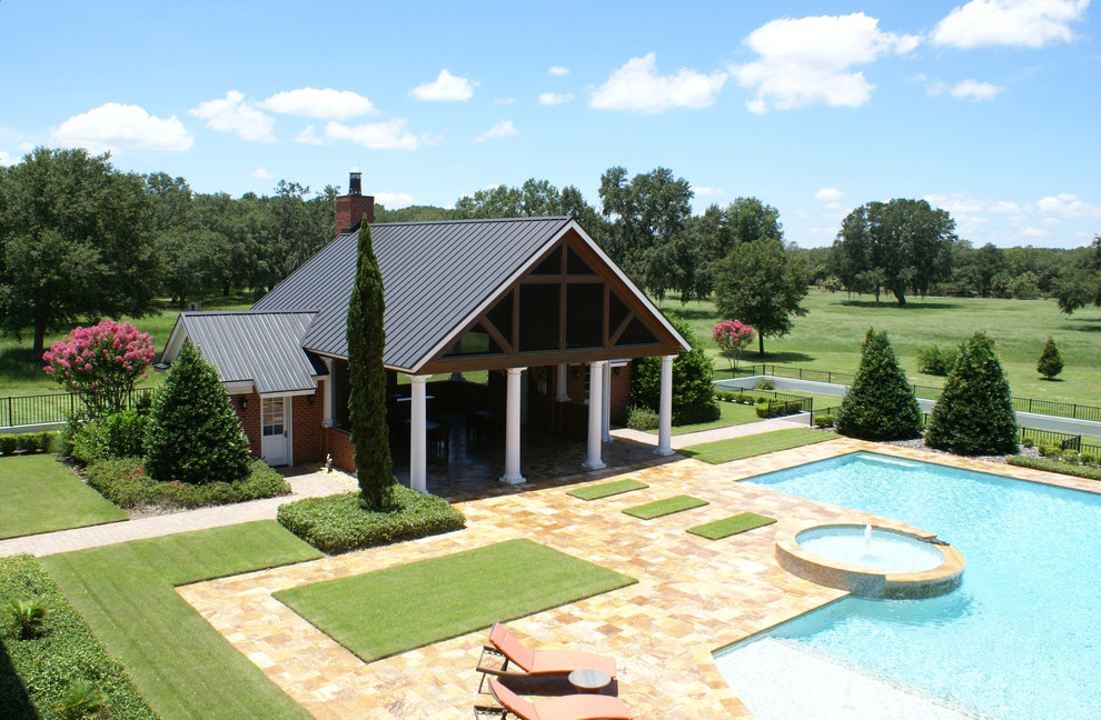 Esempio di un'ampia piscina classica personalizzata dietro casa con una vasca idromassaggio e pavimentazioni in pietra naturale