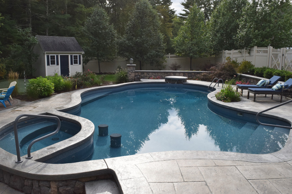 Ispirazione per una piscina monocorsia classica a "C" di medie dimensioni e dietro casa con una dépendance a bordo piscina e cemento stampato