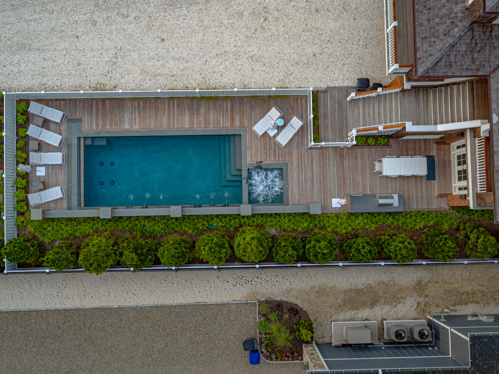 Immagine di una piscina stile marino rettangolare di medie dimensioni e davanti casa con pedane
